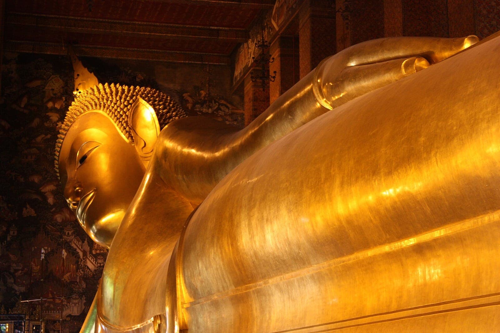 Head and shoulders of the gold Reclining Buddha statue inside Wat Pho temple in Bangkok