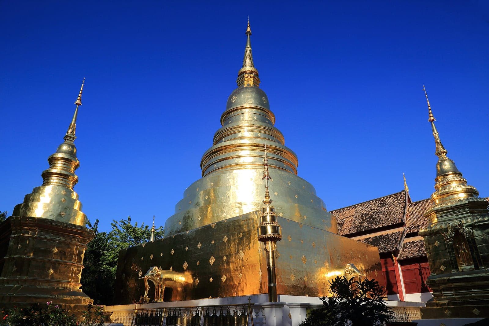 Golden chedi of Wat Phra Singh in Chiang Mai against a clear blue sky