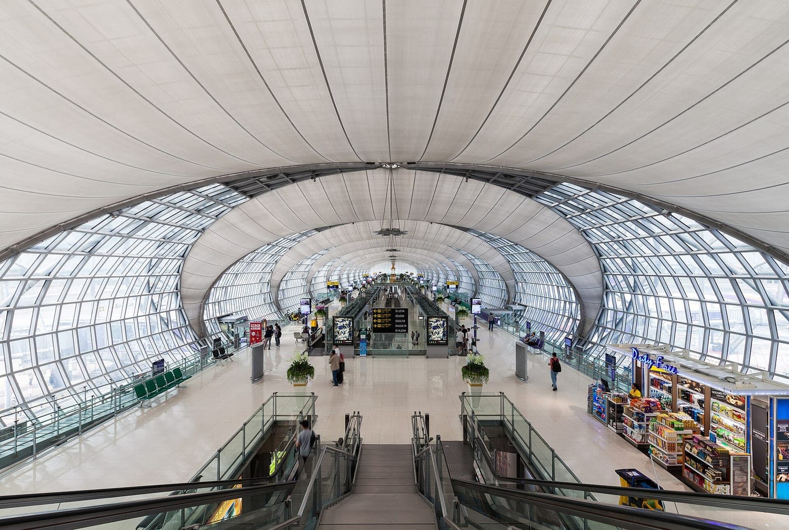 Interior of Terminal C at Suvarnabhumi Airport in Bangkok, with its vaulted steel-and-glass roof and moving walkways